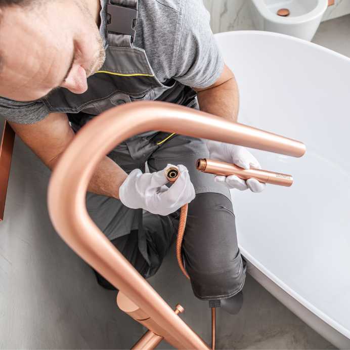 Plumber installing a soaker tub as part of a residential bathroom renovation.